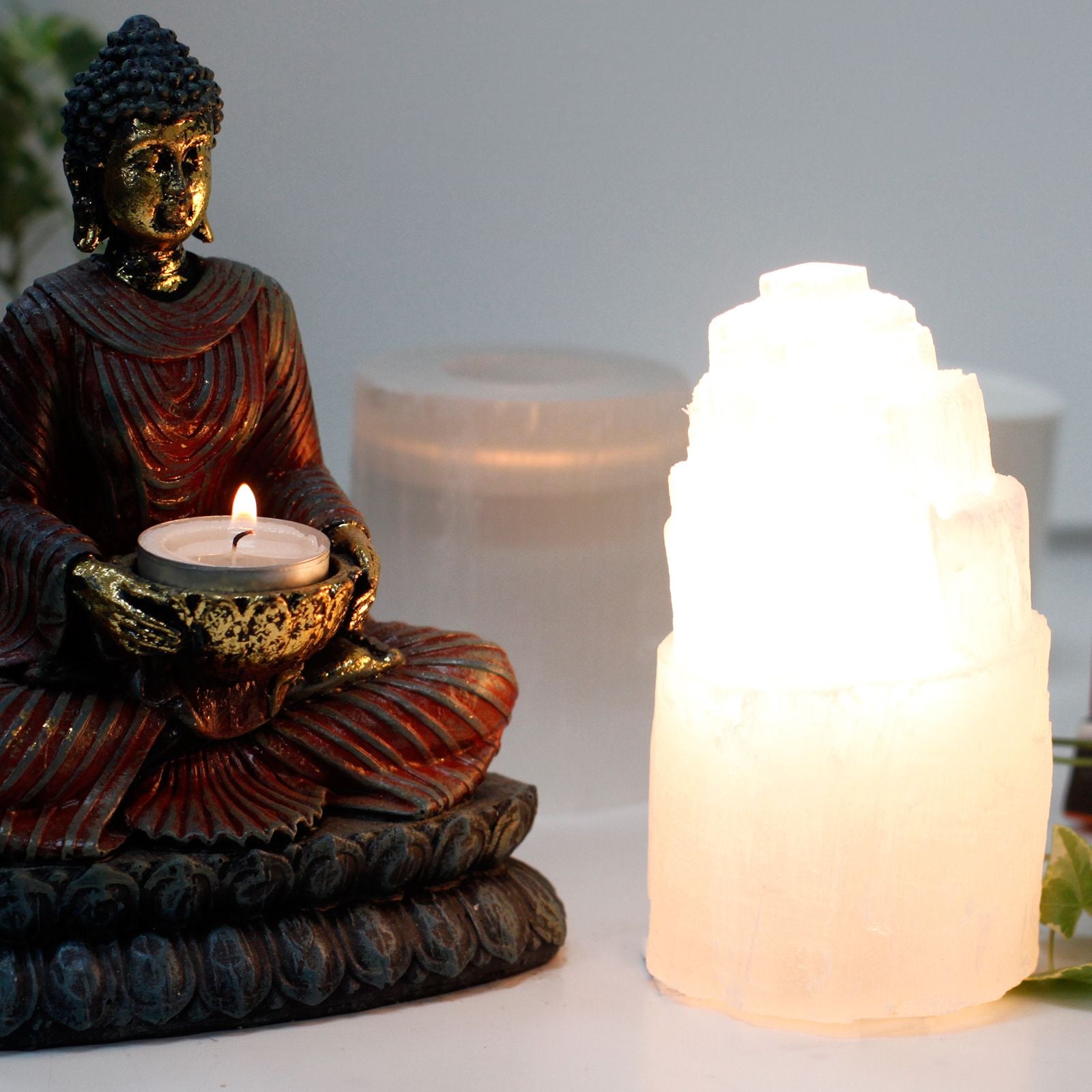 A natural, cloudy-white Selenite crystal carved into a tiered tower shape, illuminated from within.