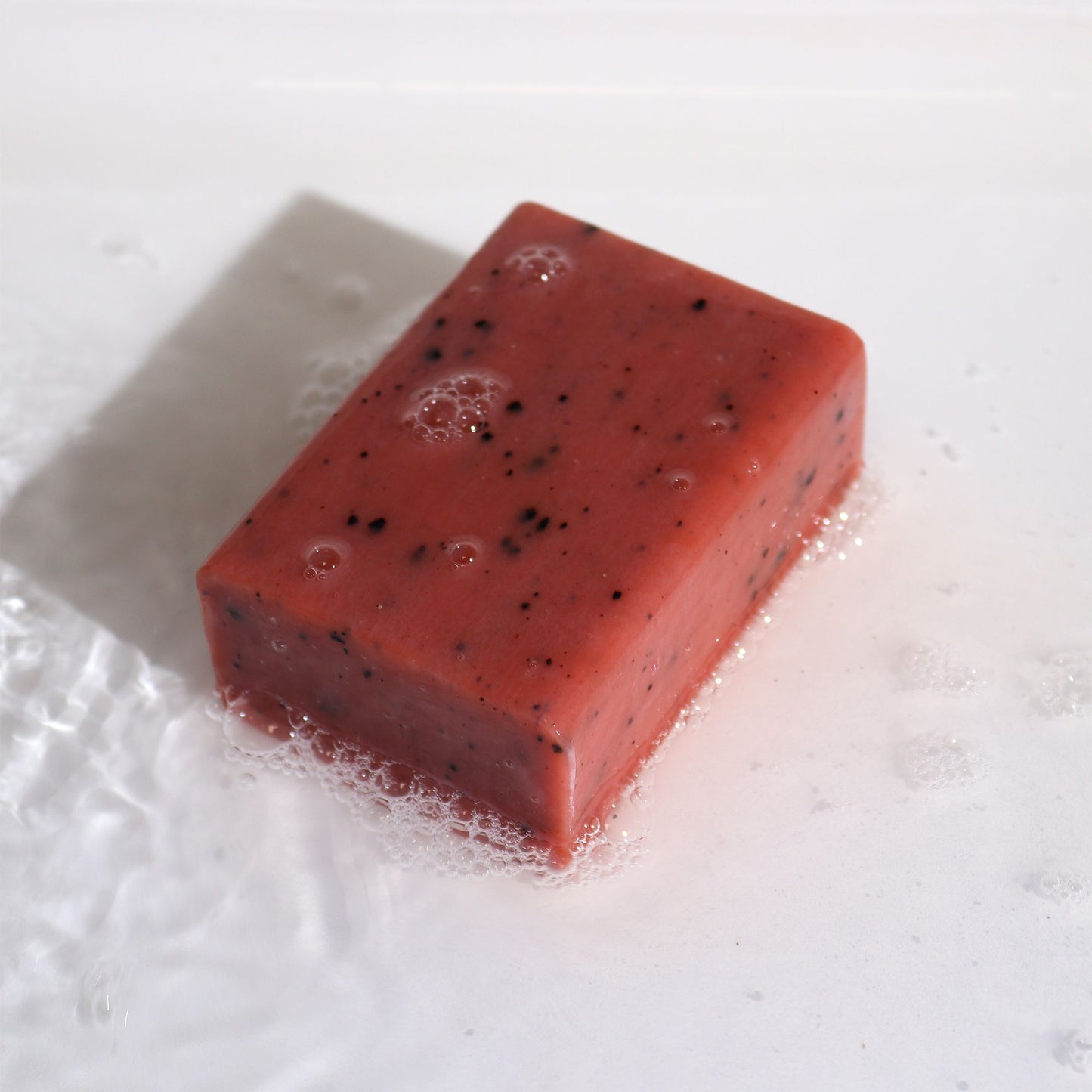 Artisan Orange & Ginger energising botanical soap block with natural coffee grounds.