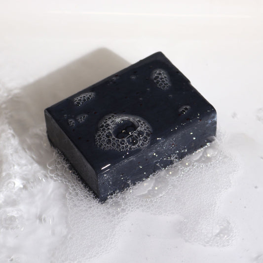 Artisan Bergamot & Sandalwood purifying botanical soap block with cranberry seeds.