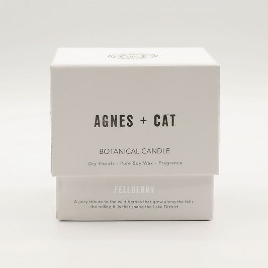 Agnes + Cat Fellberry botanical soy wax candle in a clear glass vessel with a wooden wick and dried floral petals