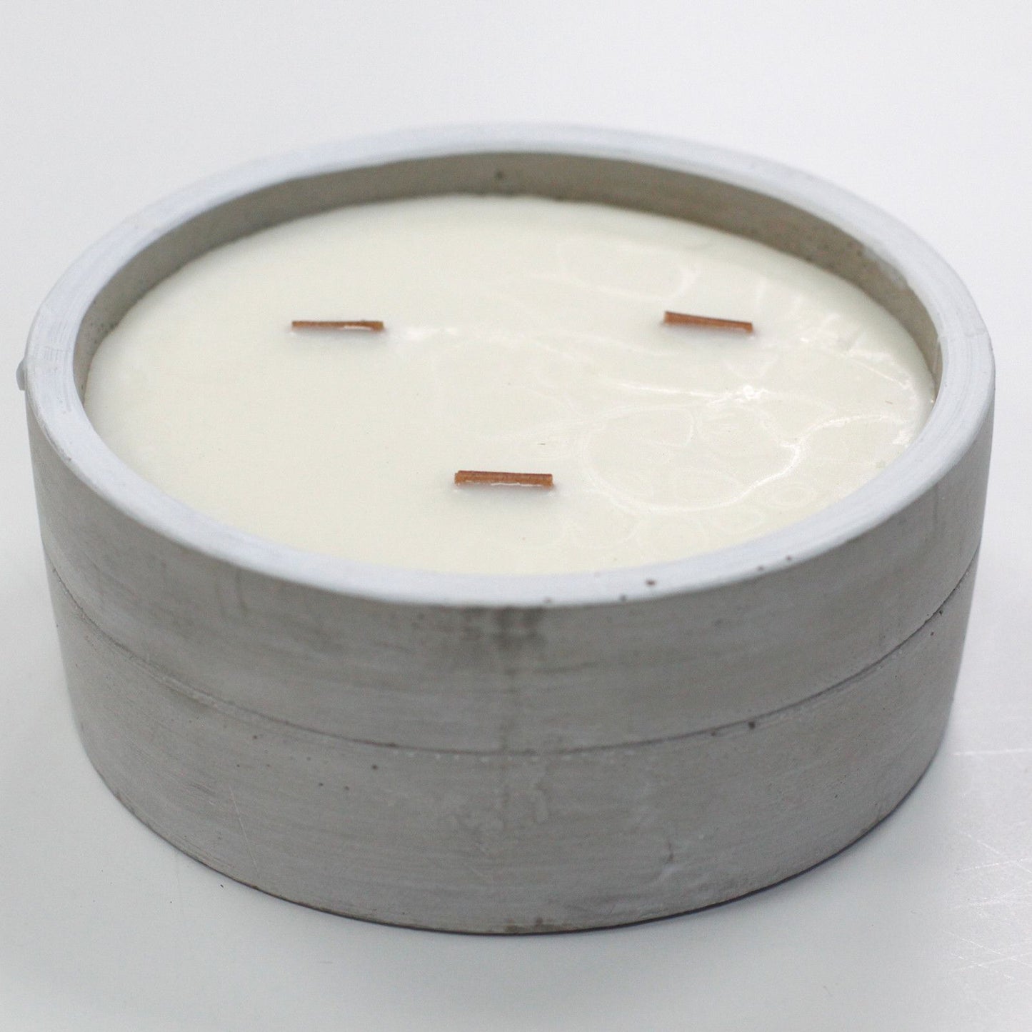 Large Patchouli & Dark Amber botanical wood-wick candle in a minimalist raw concrete bowl.