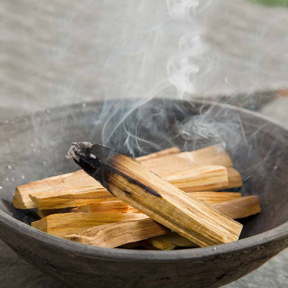 A natural kraft paper pouch filled with raw, sustainably sourced Palo Santo wood sticks.
