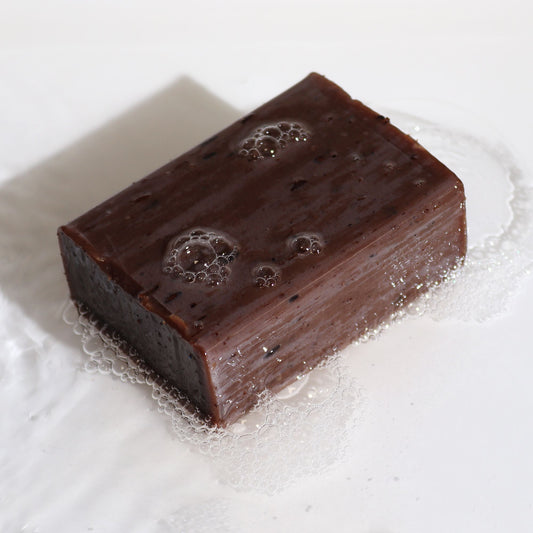 Artisan Lavender & Vanilla botanical soap block with natural lavender seeds.