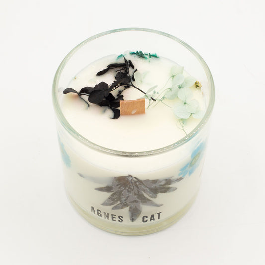 Agnes + Cat Sea Salt & Moss botanical soy wax candle in a glass jar, featuring real dried botanicals and a natural wood wick for a clean burn.