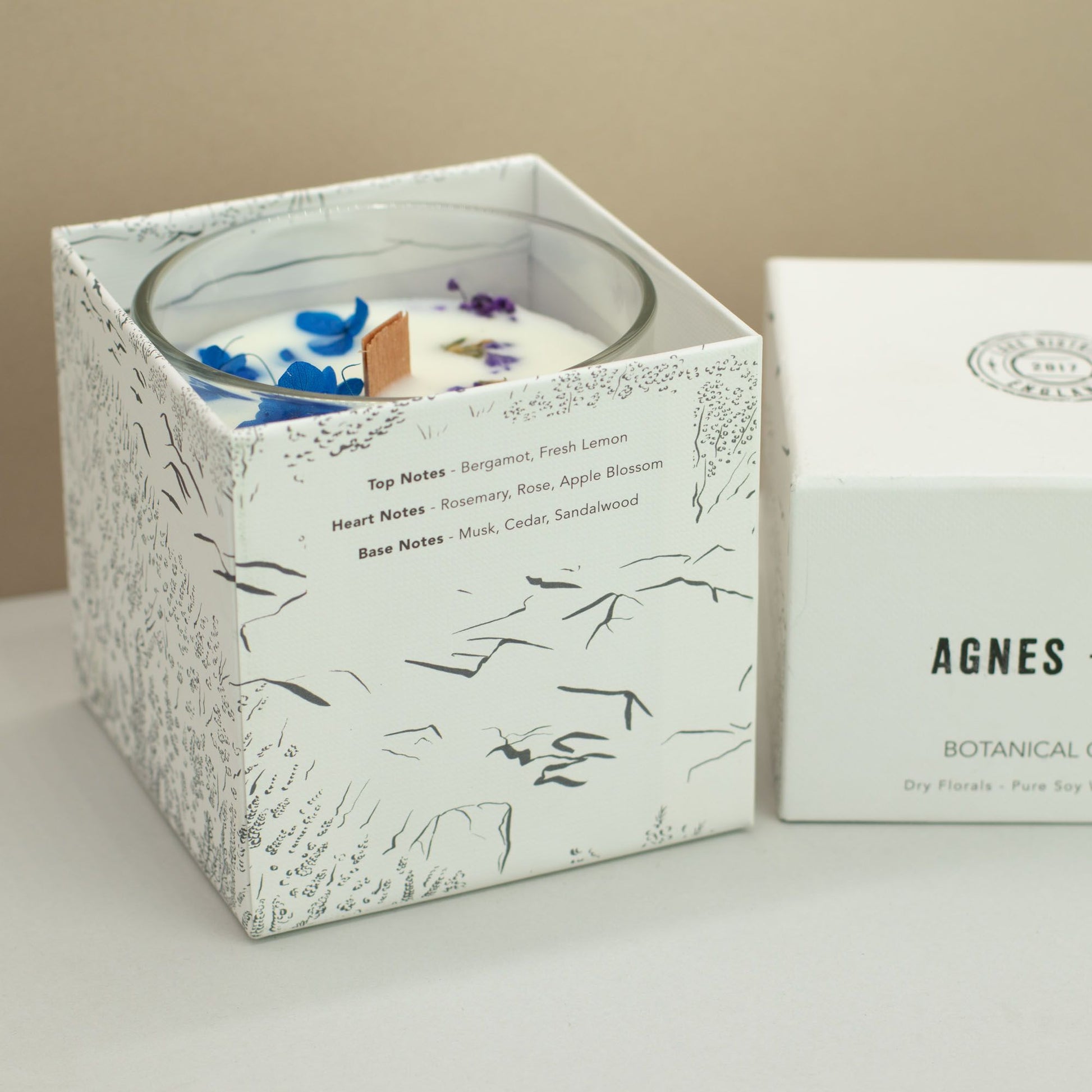 Agnes + Cat Moorland botanical soy wax candle featuring real dried florals, a natural wooden wick, and hand-drawn illustrated gift box.