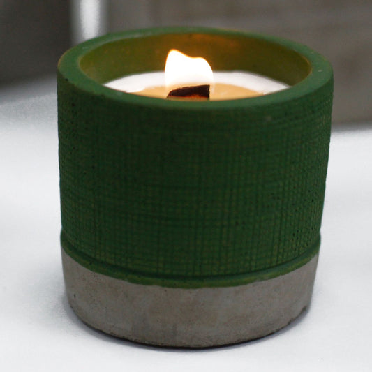 Sea Moss & Herbs botanical wood-wick candle in a forest-green concrete pot.